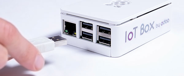 A hand connecting a USB plug to the Binqiyun IoT box